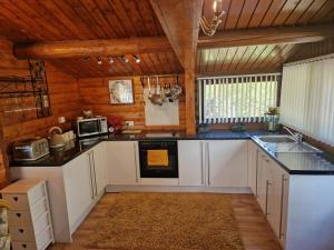 a kitchen with white cabinets and a stove at Cabin Retreat in Trawsfynydd
