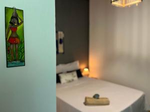 a room with a bed with a table and a picture on the wall at Caju com Mel Hospedagem in Moreré +92 photos