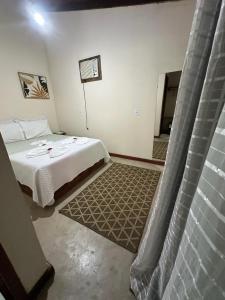 a hotel room with a bed and a window at Pousada Meraki Paraty Mirim in Paraty