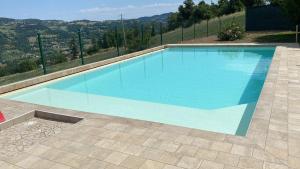 a blue swimming pool with a view of the hills at Agriturismo Casa Gianino in Acquaria