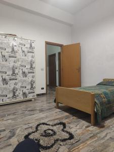 a bedroom with a bed and a wall covered in posters at Bella Reggio in Reggio di Calabria +1 photo