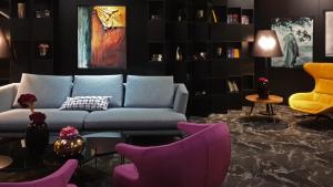 a living room with a blue couch and purple chairs at Hotel Arka in Skopje