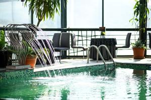 a swimming pool with water fountains in a building at Hotel Arka in Skopje