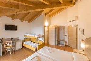 a room with two beds and a desk and a tv at Agritur Giovanazzi in Arco