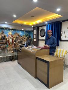 a man standing at a counter in a store at Hotel Aman in Patna