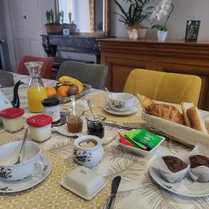 ein Tisch mit einem Frühstück aus Brot und Kaffee in der Unterkunft L'Armancine, chambres d'hôtes in Saint-Florentin + 20 Fotos