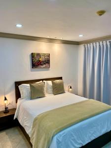 a bedroom with a large bed with white sheets at BUENAVISTA INN in Maiquetía