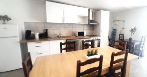 a kitchen with a wooden table and a table and chairs at Appartement 8pers à Vallères in Vallères +17 photos