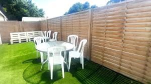 a table and chairs in a backyard with a fence at Appartement 8pers à Vallères in Vallères