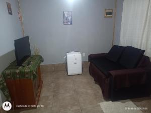 a room with a bed and a tv and a couch at Casa VillaOliva in Ciudad Lujan de Cuyo
