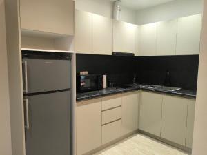 a kitchen with white cabinets and a stainless steel refrigerator at Apartment in Verin Apart hotel in Dilijan in Dilijan