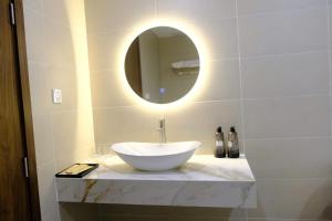 a bathroom with a white sink and a mirror at KHEM BEACH Hotel in Phú Quốc +51 photos