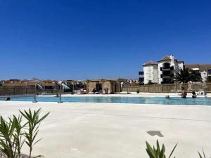 a swimming pool in the middle of a city at les pieds dans l'eau 1-Piscine chauffée in Le Barcarès