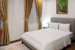 a bedroom with a white bed and curtains at KHEM BEACH Hotel in Phú Quốc