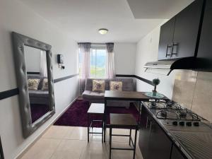 a small kitchen and living room with a couch at apta estudio oronegro amanecer in Armenia