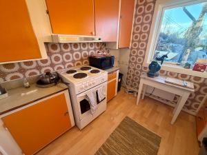 a kitchen with a stove and a sink and a window at Sea View apartment in Askøy