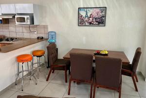 a kitchen with a wooden table and chairs and a counter at CIELITO LINDO casa de lujo con alberca 3 habitaciones in Mezcales