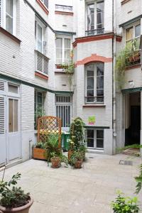 a courtyard in front of a building with potted plants at Apartment Bac St. Germain in Paris