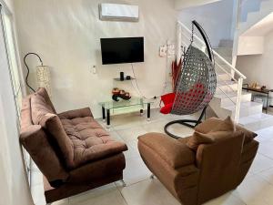 a living room with two chairs and a tv at CIELITO LINDO casa de lujo con alberca 3 habitaciones in Mezcales