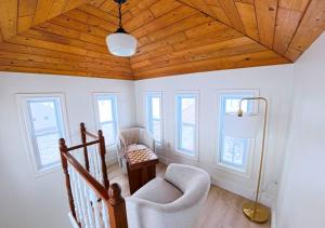 a room with two chairs and a ceiling with wood at Saltwater Steeple in Port Saunders