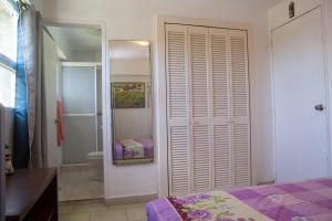 a bedroom with a bed and a bathroom with a mirror at #BaraticoEnMargaritaEsCool in Porlamar