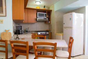a kitchen with a table and a white refrigerator at #BaraticoEnMargaritaEsCool in Porlamar +3 photos
