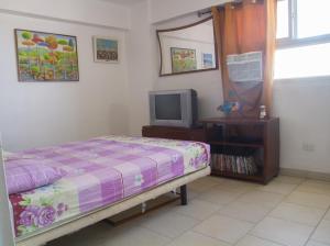 a bedroom with a bed and a tv at #BaraticoEnMargaritaEsCool in Porlamar