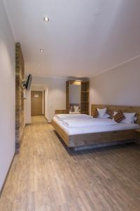 a large bedroom with a large bed and wooden floors at Landgasthaus Grüner Baum in Simonswald