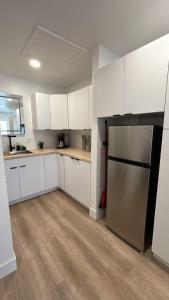 a kitchen with white cabinets and a stainless steel refrigerator at #3 Hygge Hus Hotel - King Suite Connectable in Andrews