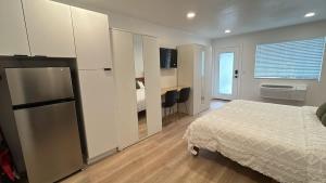 a bedroom with a bed and a refrigerator in it at #3 Hygge Hus Hotel - King Suite Connectable in Andrews