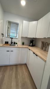 a kitchen with white cabinets and a counter top at #3 Hygge Hus Hotel - King Suite Connectable in Andrews