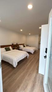 two beds in a large room with wooden floors at #4 Hygge Hus Hotel - Double Room Suite Connectable in Andrews