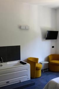 a room with a bed and two chairs and a tv at Da Zoe suite fontanavecchia in Vernazza