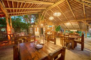ein Restaurant mit einem Holztisch und Holzstühlen in der Unterkunft Cabalonga EcoAdventure in Puerto Cayo