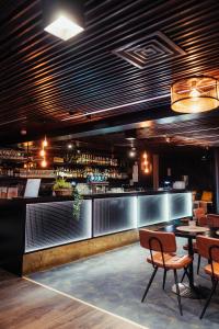a restaurant with a bar with tables and chairs at Hotel Emilia in Hämeenlinna