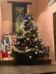 a christmas tree with ornaments on it in a room at Maison d’hôtes les Méans in Méolans