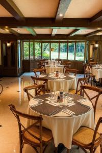 a restaurant with white tables and chairs and windows at Hotel Casagrande in Arequipa