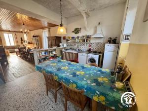 a kitchen with a table with a blue table cloth at La maison in Davejean