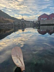 a person is paddling a canoe in a body of water at Grønningbrygga in Grønning