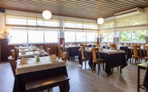 a dining room with tables and chairs and windows at Hotel Eurosol Seia Camelo in Seia