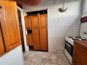 a small kitchen with wooden cabinets and a stove at La cachette du Beffroi - Appt 30 m² centre Arras in Arras