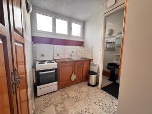 a small kitchen with a stove and a window at La cachette du Beffroi - Appt 30 m² centre Arras in Arras