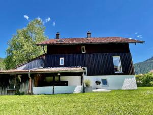 a large black and white house with a grass yard at Ferienhaus Ferienwohnung CasaBergZeit mit Königscard im Allgäu, Pfronten, Füssen in Pfronten