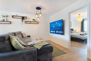 a living room with a couch and a tv at Spacious & Modern Apt - Balcony & Parking in Spiez