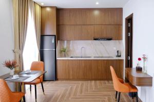 a kitchen with a refrigerator and a table and chairs at KHEM BEACH Hotel in Phú Quốc
