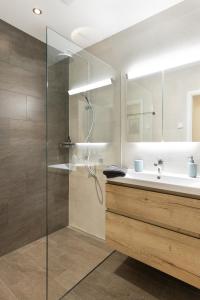 a bathroom with a glass shower and a sink at Spacious & Modern Apt - Balcony & Parking in Spiez