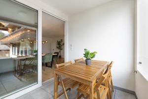 a dining room with a wooden table and chairs at Spacious & Modern Apt - Balcony & Parking in Spiez +28 photos