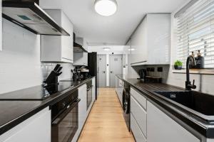 a large kitchen with white cabinets and black appliances at The Reading Hub in Reading +39 photos