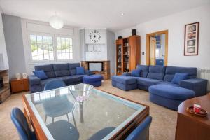 a living room with blue couches and a glass table at Nature & Tranquility only 25km from Barcelona in Torrelles de Llobregat