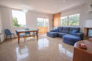 a living room with a blue couch and a table at Nature & Tranquility only 25km from Barcelona in Torrelles de Llobregat